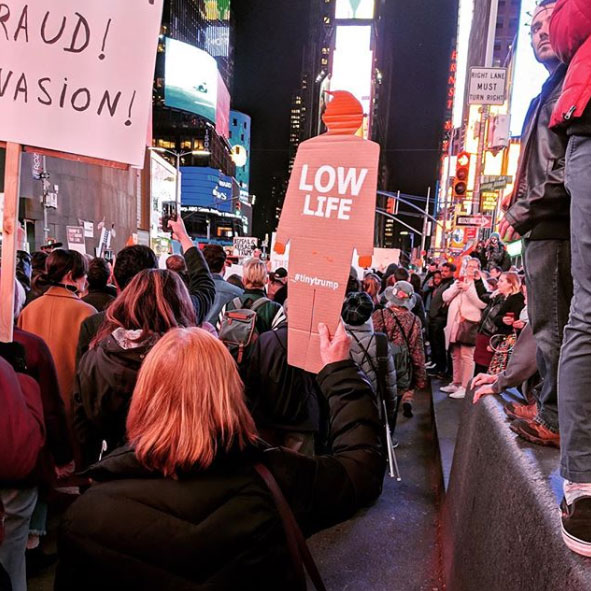 'Low Life' tiny trump being used as a protest sign in New York City's Times Square