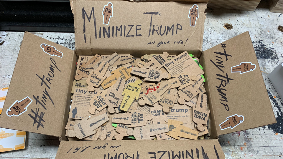 hundreds of tiny trumps in a box free for anyone to take